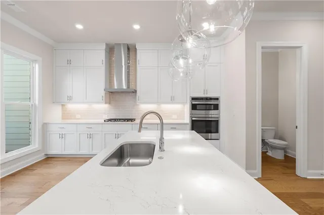 a kitchen with stainless steel appliances granite countertop white cabinets and a stove