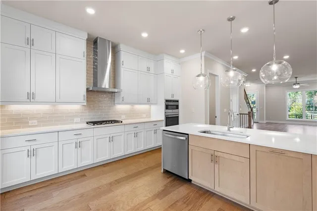 a kitchen with kitchen island white cabinets and stainless steel appliances