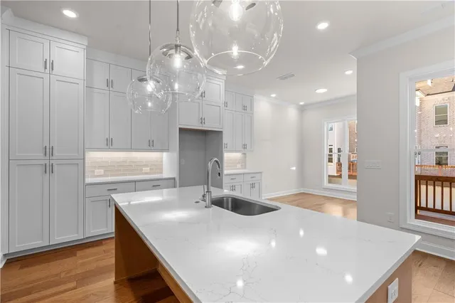 a large white kitchen with a sink and dishwasher stove with wooden floor