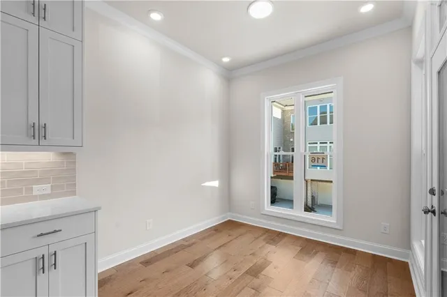 an empty room with wooden floor and a ceiling fan