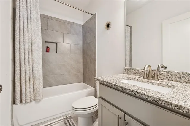 a bathroom with a granite countertop sink a toilet and bathtub