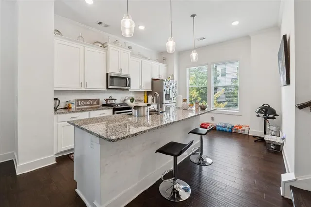 a kitchen with stainless steel appliances granite countertop a lot of counter space and wooden floor