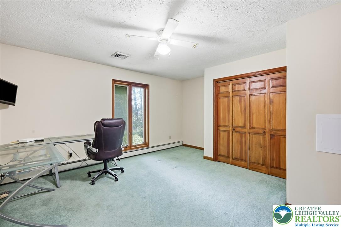 123 Meadow Road Blakeslee, PA 18610 - Photo 28 of 53 A spacious room features classic wood bi-fold closet doors and wood-framed windows overlooking the trees.