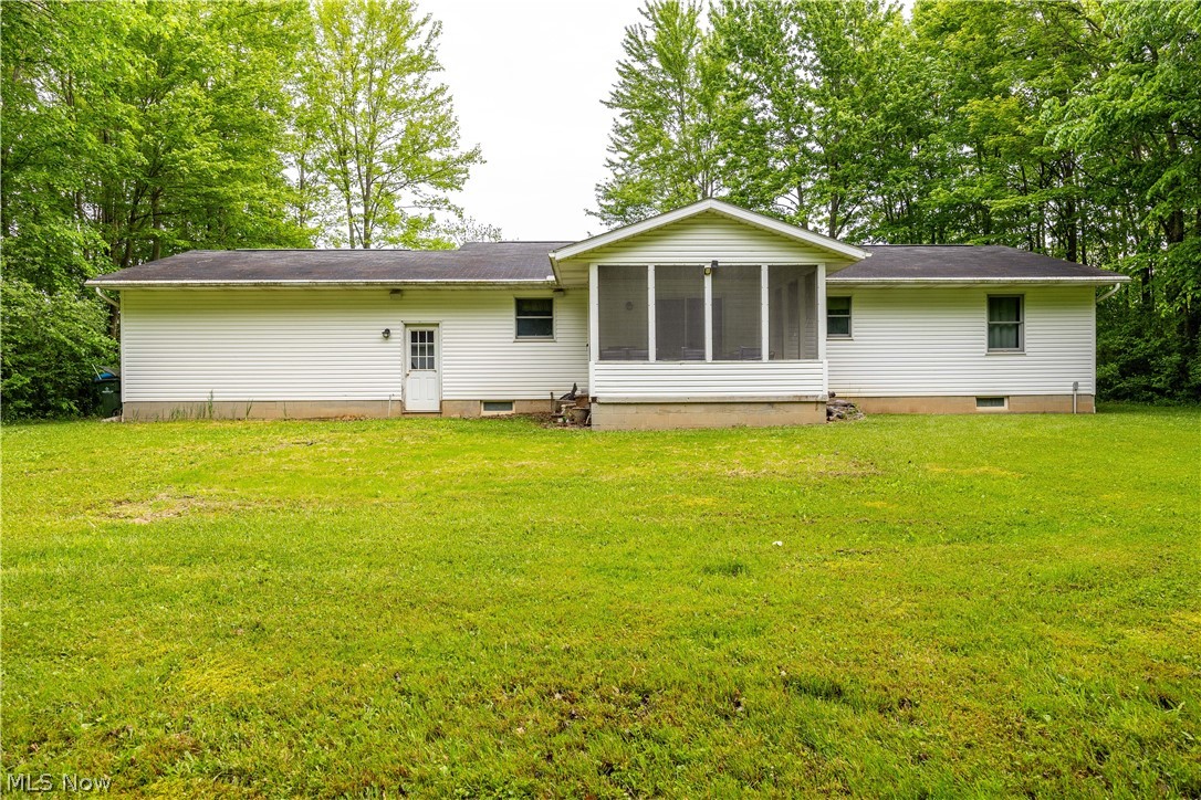 Rear view of property featuring a lawn