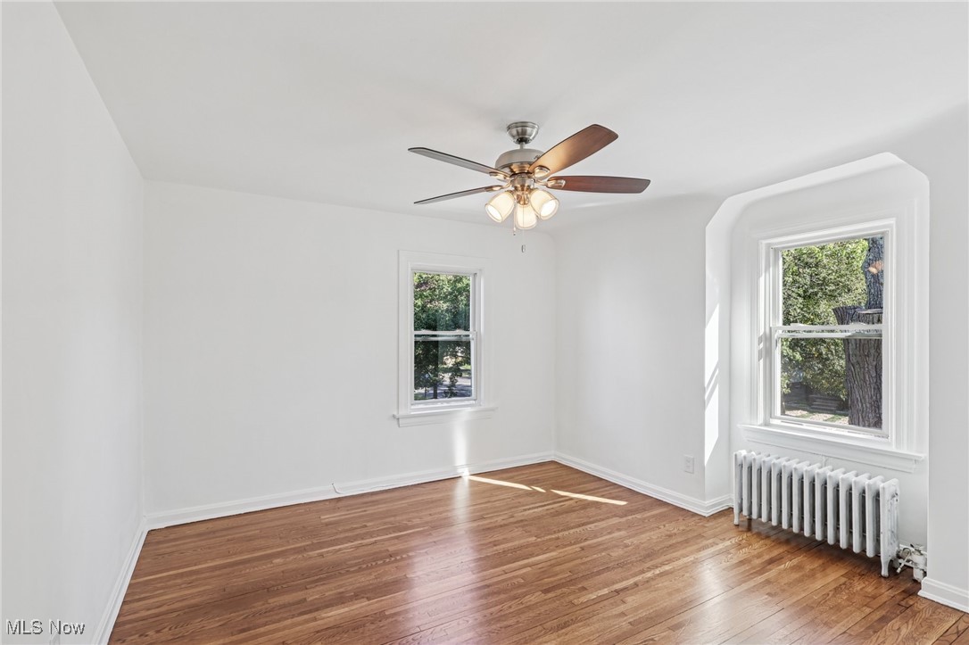 3621 Cedarbrook Road Cleveland, OH 44118 - Photo 22 of 40 Unfurnished room with radiator, wood finished floors, and a ceiling fan