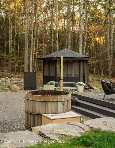 a view of a house with a big yard plants and large tree
