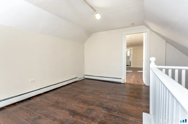 a view of a hallway with wooden floor
