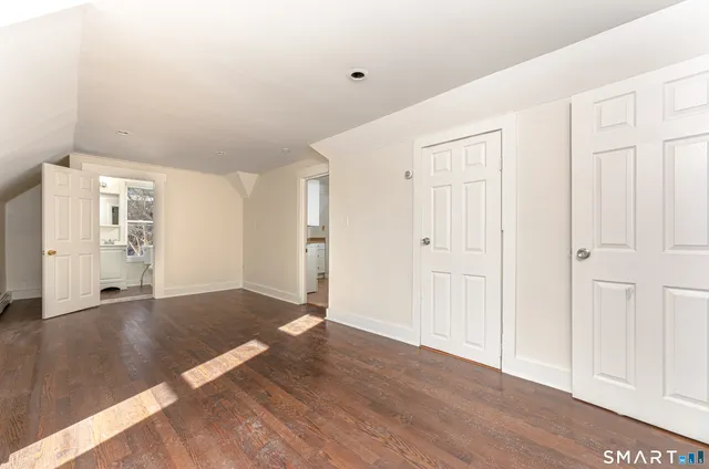 a view of an empty room with wooden floor