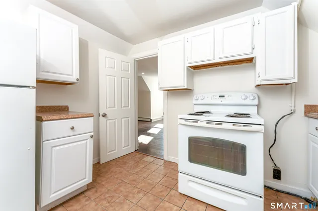 a kitchen with white cabinets and white appliances