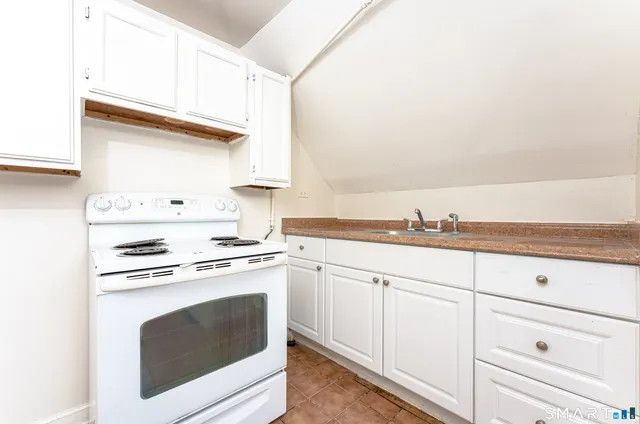 a kitchen with granite countertop white cabinets and white appliances