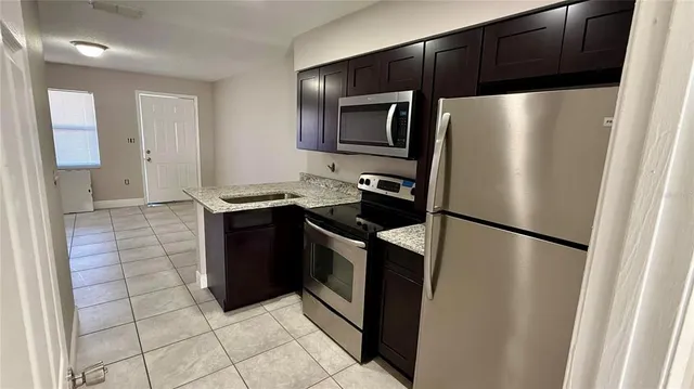 a kitchen with stainless steel appliances granite countertop a refrigerator and a sink