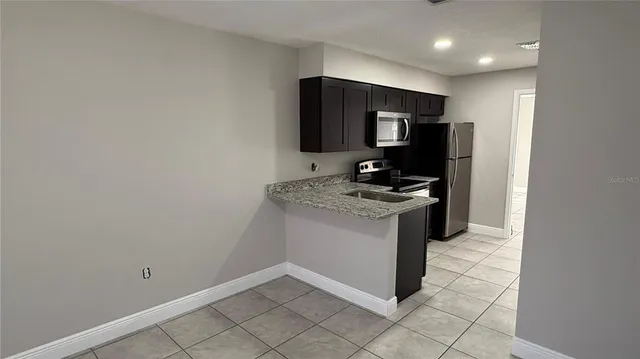 a kitchen with a refrigerator and a stove top oven