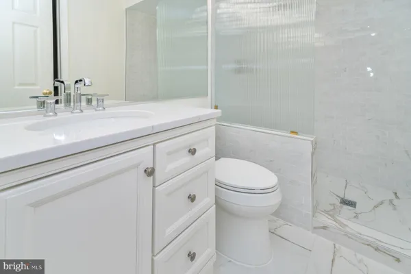 a bathroom with a sink a toilet and a mirror