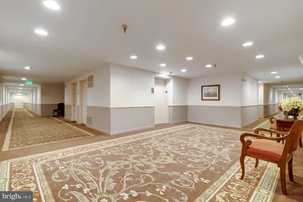 a view of an empty room with kitchen and furniture