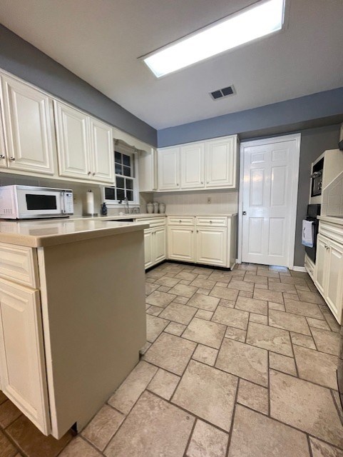 4537 Sears Road Columbus, GA 31907 - Photo 7 of 41 a kitchen with a sink a stove top oven and cabinets