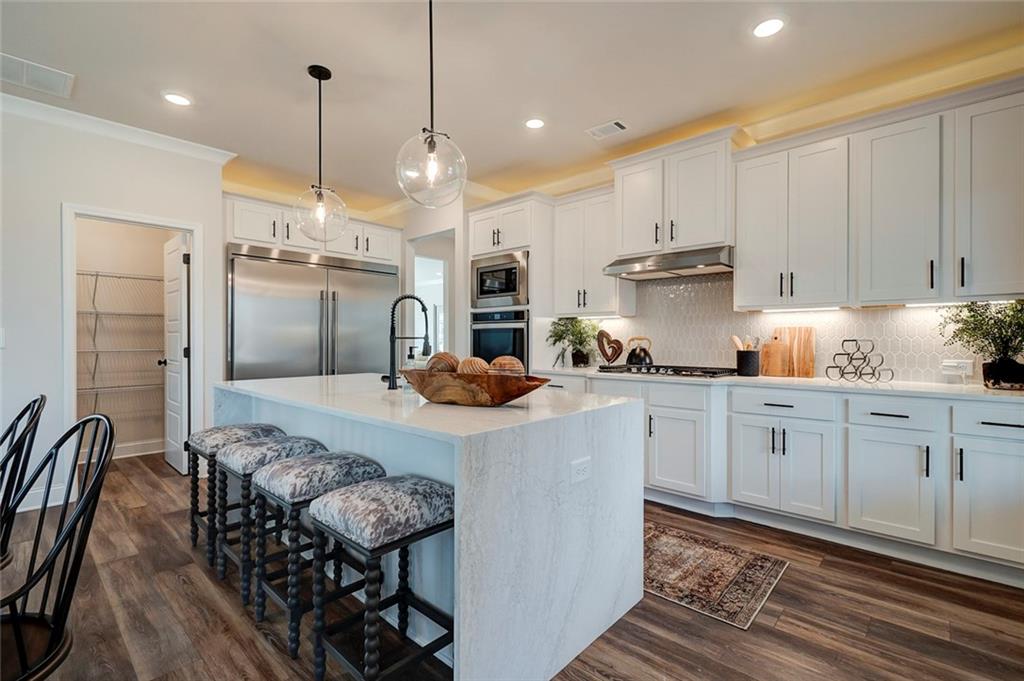 15 Cardinal Rdg Court Winder, GA 30680 - Photo 15 of 86 a kitchen with stainless steel appliances granite countertop a stove a sink a refrigerator and white cabinets with wooden floor