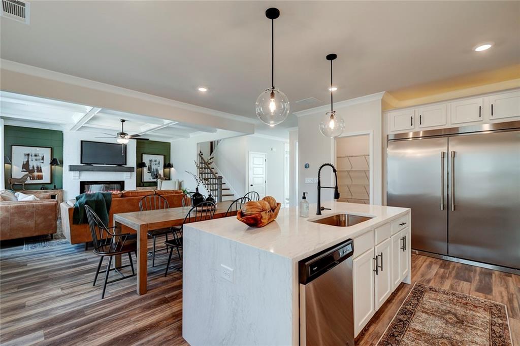 15 Cardinal Rdg Court Winder, GA 30680 - Photo 18 of 86 a kitchen with stainless steel appliances kitchen island granite countertop a table chairs in it and wooden floors