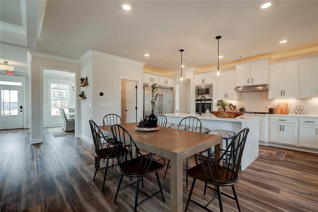 15 Cardinal Rdg Court Winder, GA 30680 - Photo 7 of 86 a view of a dining room and livingroom with furniture wooden floor kitchen appliances and a chandelier