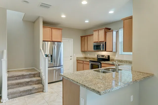 a kitchen with stainless steel appliances granite countertop a refrigerator and a sink