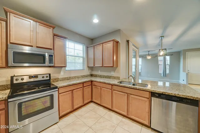 a kitchen with stainless steel appliances granite countertop a sink stove and microwave