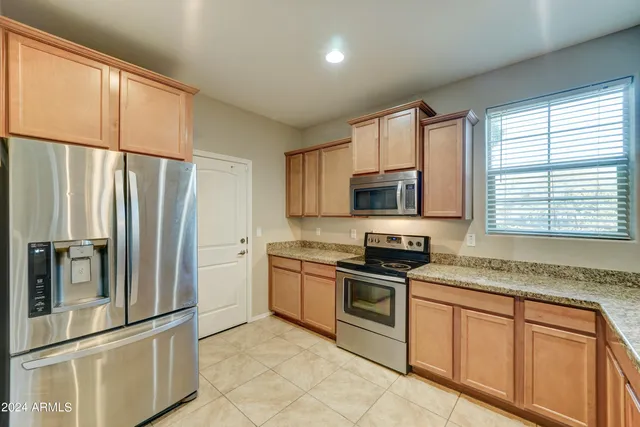 a kitchen with stainless steel appliances granite countertop a refrigerator sink and stove