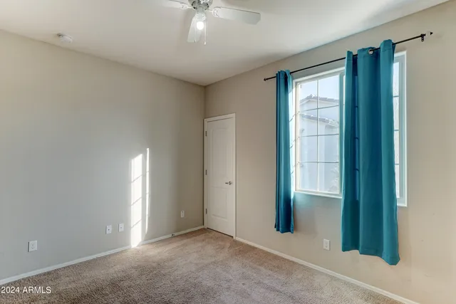 an empty room with chandelier fan