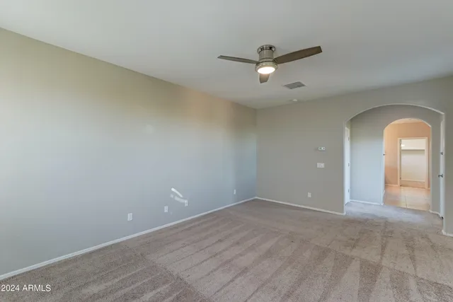 an empty room with a ceiling fan and window