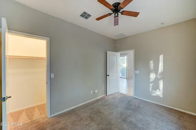 a view of a room with a ceiling fan and a window