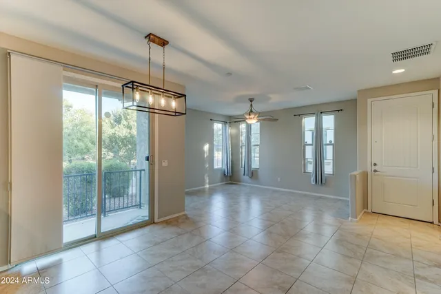 a view of an empty room with glass door and windows