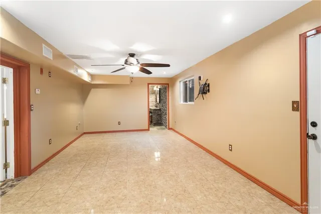 en empty room with windows and ceiling fan