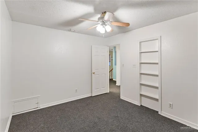 a view of an empty room with a ceiling fan