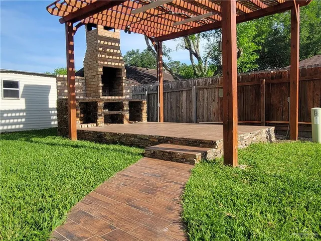 a view of a house with a small yard and wooden fence