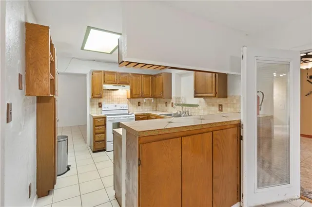 a kitchen with stainless steel appliances a sink cabinets and a window