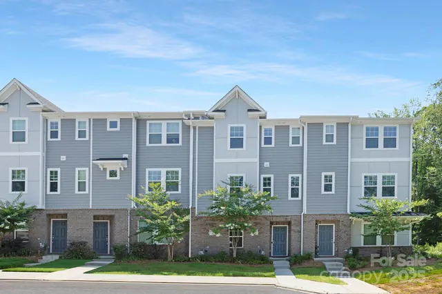 a front view of residential houses with yard and green space