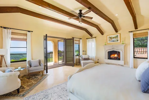 a large bedroom with a large bed and a fireplace