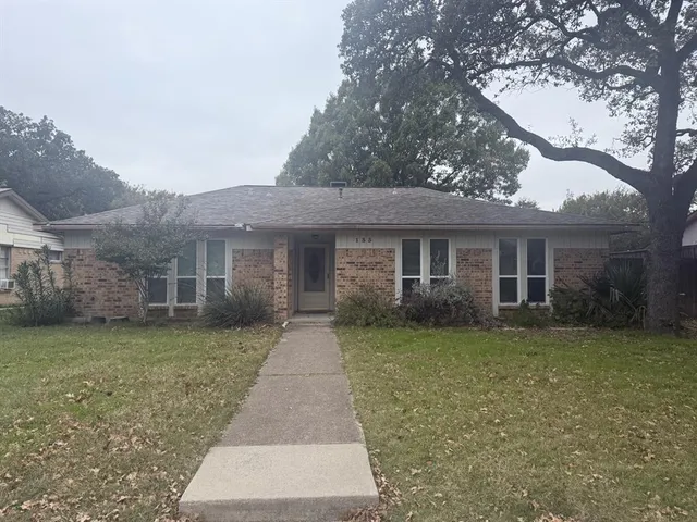a front view of a house with a garden and yard