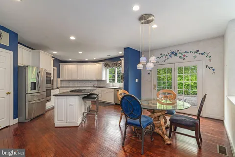a view of a dining room with furniture a chandelier and wooden floor