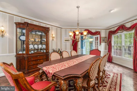 a living room with furniture a chandelier and a dining table