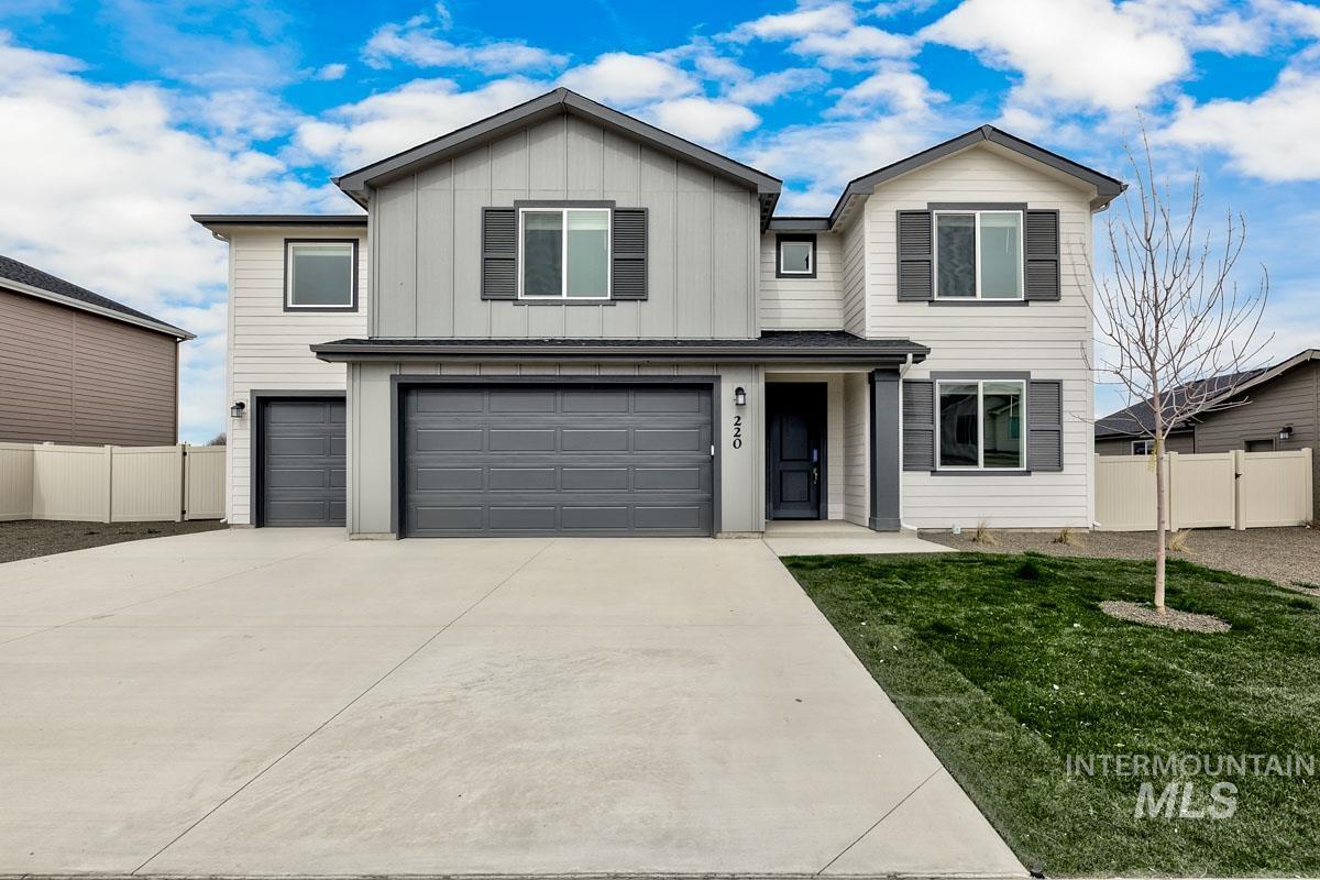 View of front facade featuring an attached garage, driveway, and board and batten siding