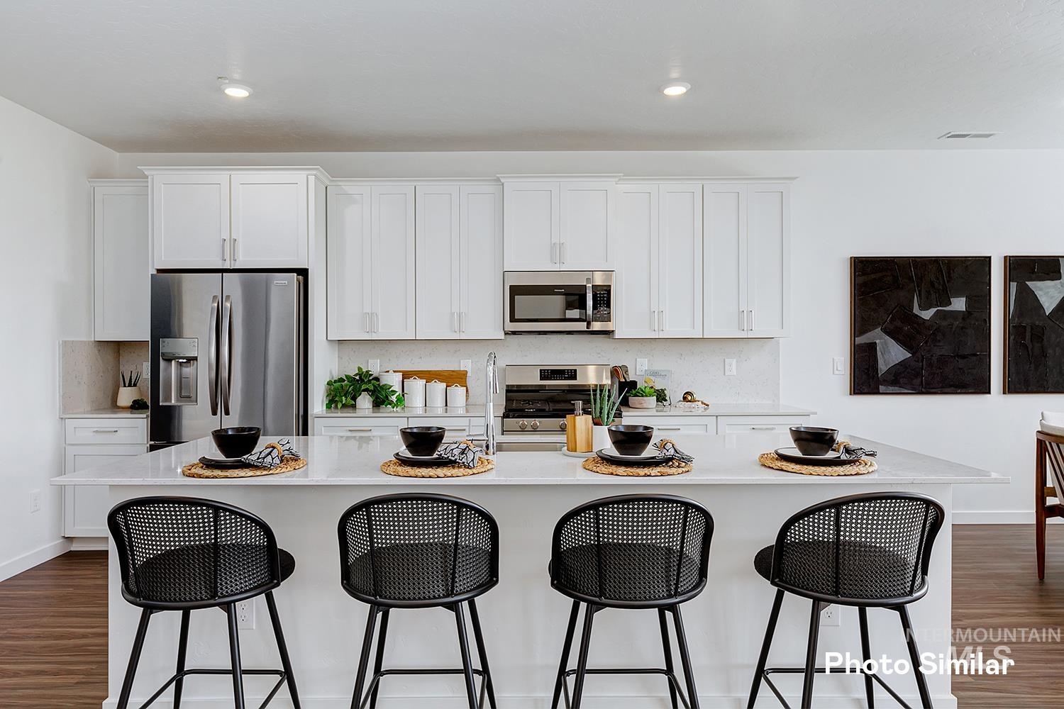 220 Ravello Street Caldwell, ID 83605 - Photo 11 of 35 Kitchen featuring dark wood finished floors, white cabinetry, backsplash, appliances with stainless steel finishes, and recessed lighting