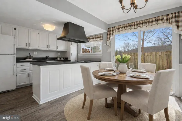 a kitchen with stainless steel appliances kitchen island granite countertop a table and chairs in it