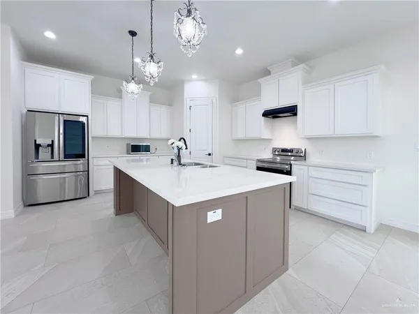 a large white kitchen with cabinets