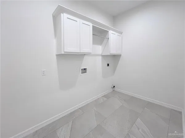 an empty room with chandelier fan and windows