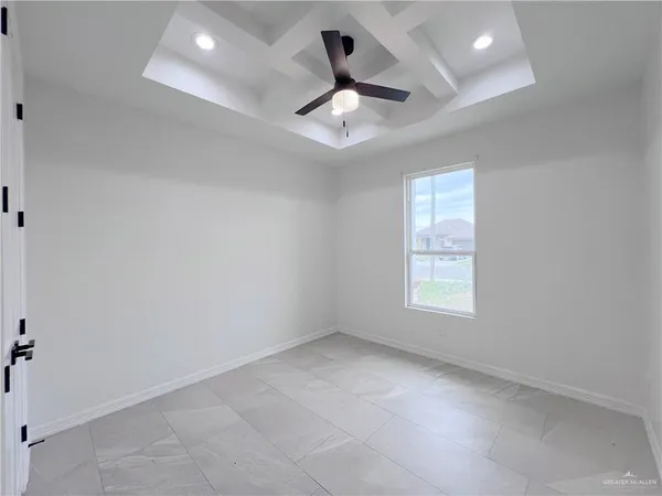 an empty room with chandelier fan