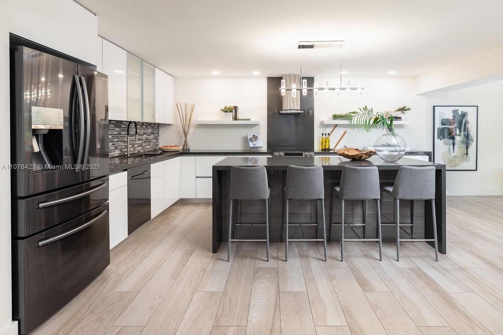 1812 Fairhaven Place Miami, FL 33133 - Photo 2 of 37 a kitchen with stainless steel appliances kitchen island granite countertop a table chairs sink and cabinets
