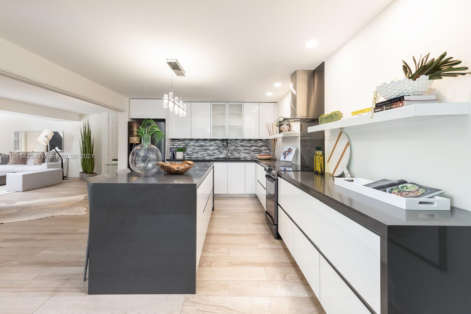 1812 Fairhaven Place Miami, FL 33133 - Photo 6 of 37 a kitchen with kitchen island granite countertop a sink stove and wooden cabinets