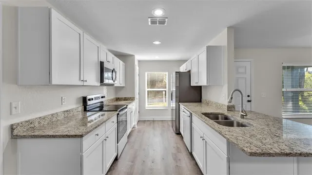 a kitchen with stainless steel appliances granite countertop a sink stove and refrigerator