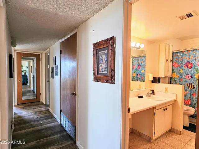 a hallway with cabinets a stove and a wooden floor