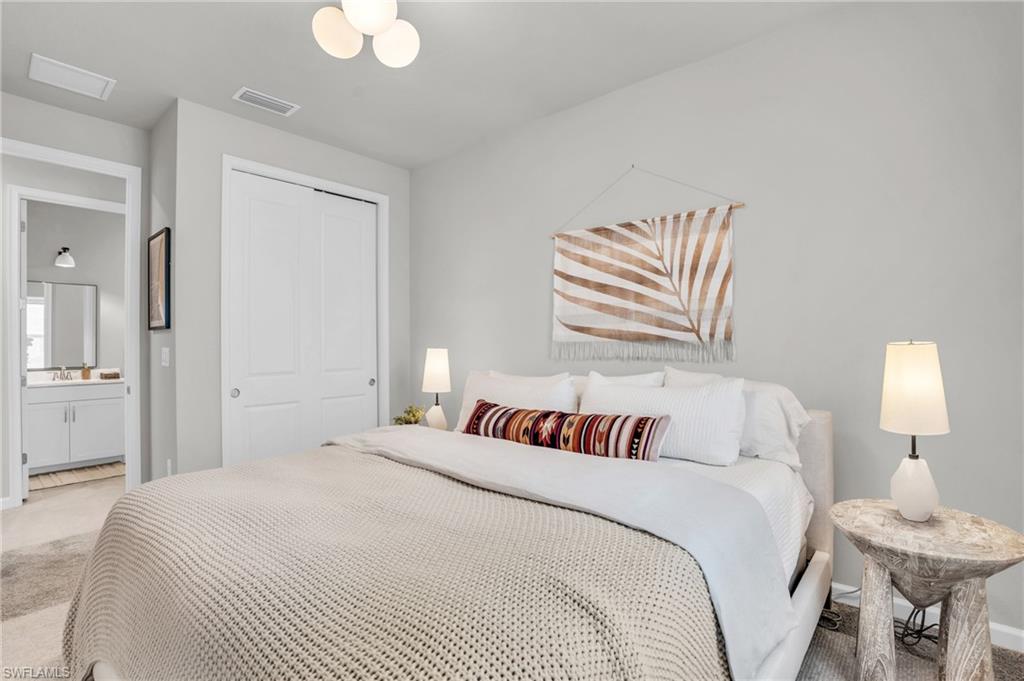 4595 Arboretum Circle, Unit 203 Naples, FL 34112 - Photo 12 of 22 a bedroom with a bed and a lamp
