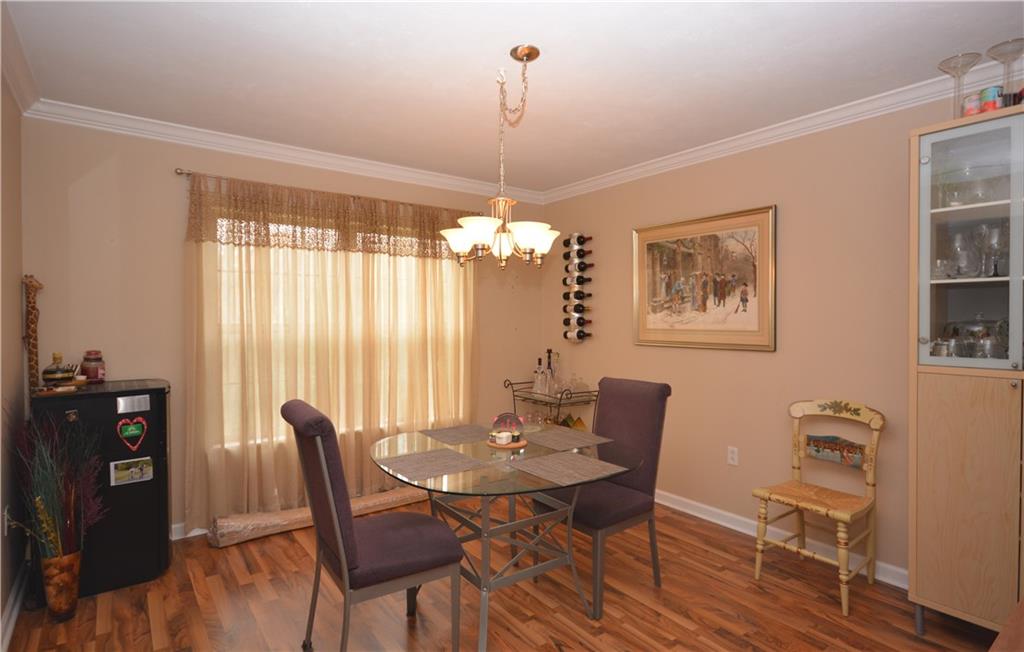 218 Grace Street McKees Rocks, PA 15136 - Photo 5 of 22 Crown molding and laminate wood flooring enhance the dining room.